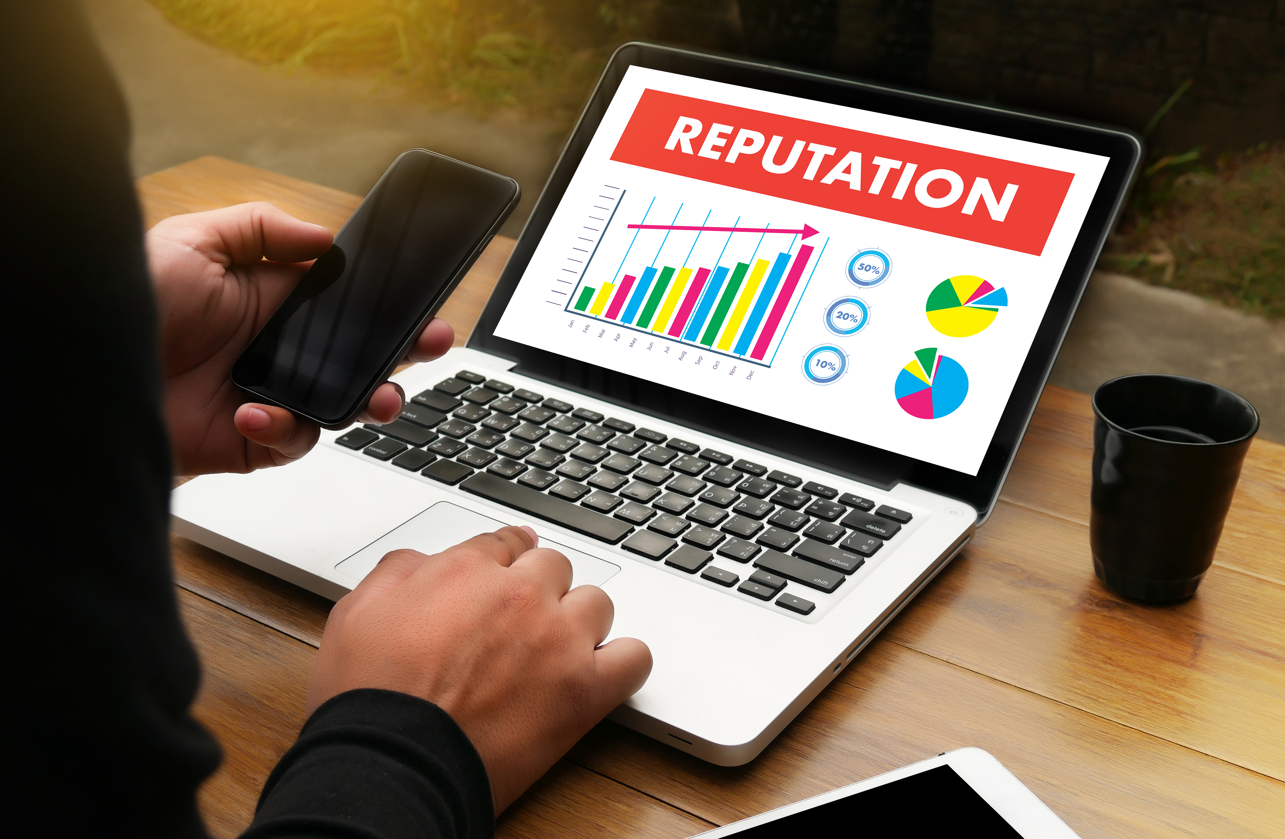 A laptop with the word Reputation on it and some graphs.